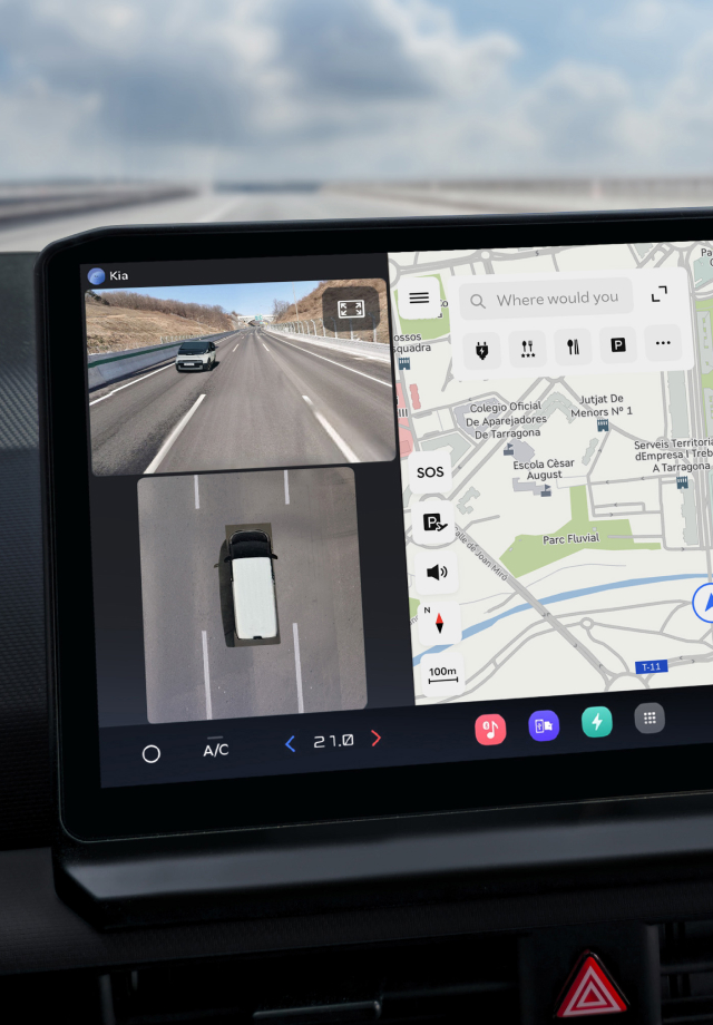 Nahaufnahme des Infotainment-Bildschirms mit Navigationskarte und Rückfahrkameraansicht.